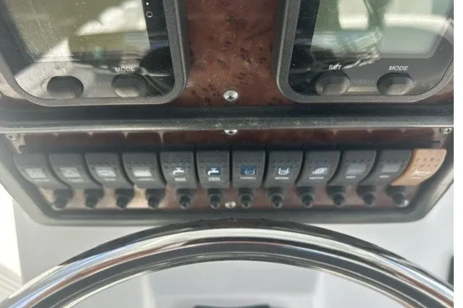 Slide: The Image of Dashboard controls of a 2013 Sea Hunt Ultra 234 boat with switches and gauges. - 5