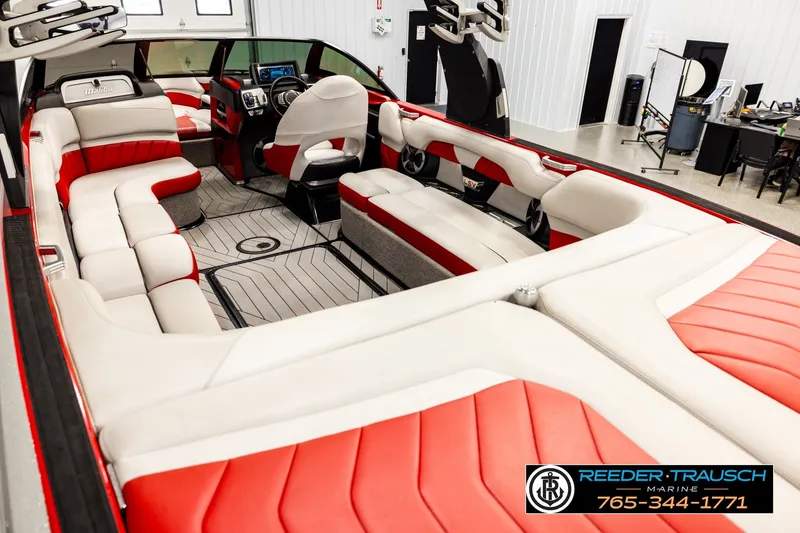 Slide: The Image of 2017 Malibu Wakesetter 25 LSV interior with red and white seating, showcased in a showroom. - 11