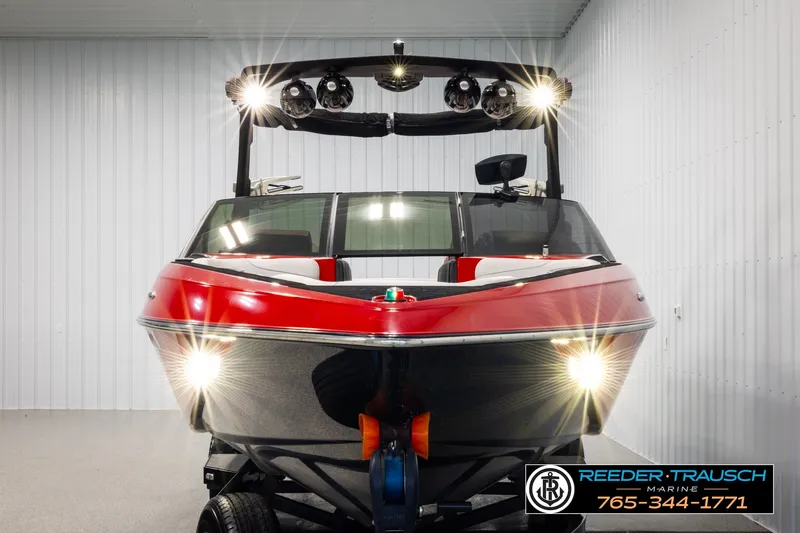 Slide: The Image of 2017 Malibu Wakesetter 25 LSV boat with bright lights in a showroom. - 8