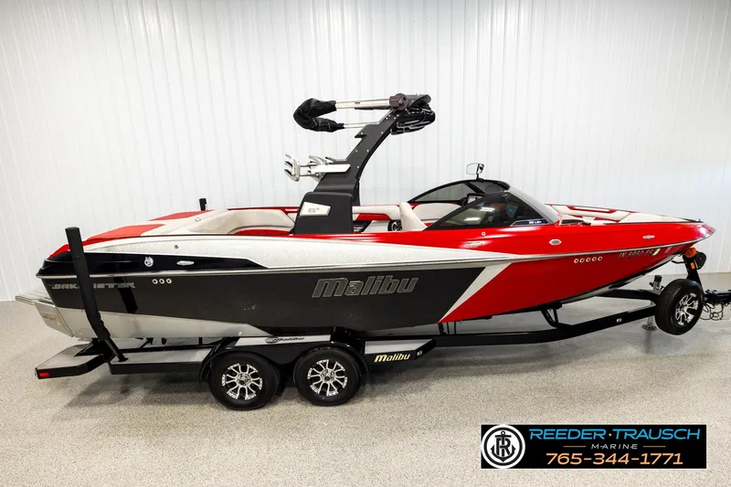The Image of 2017 Malibu Wakesetter 25 LSV boat in red and black on trailer indoors. - 1