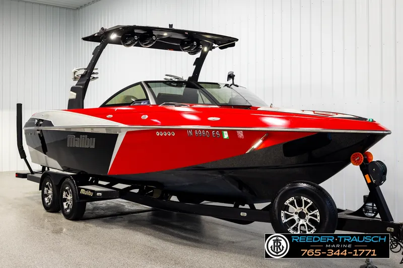 Slide: The Image of 2017 Malibu Wakesetter 25 LSV boat in red and black on trailer indoors. - 3