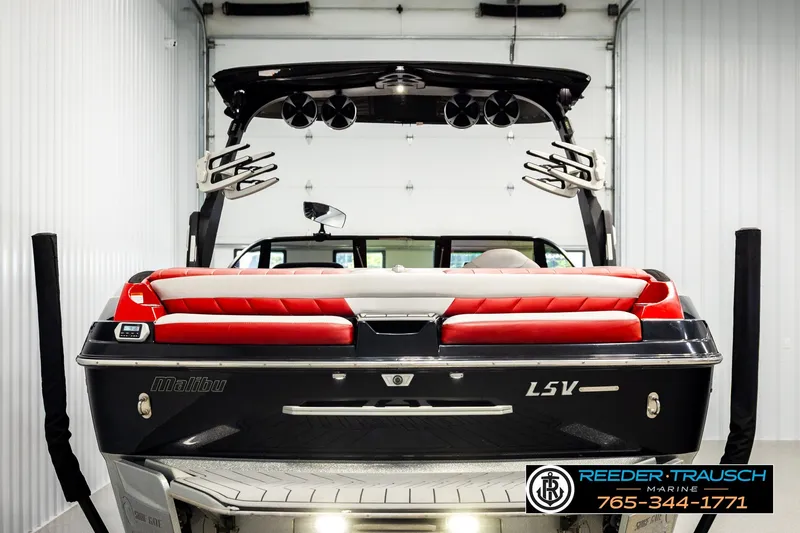 Slide: The Image of 2017 Malibu Wakesetter 25 LSV boat in showroom, featuring red and white seating. - 7