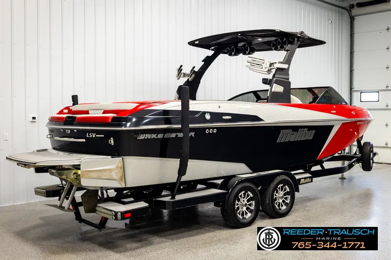 Slide: The Image of 2017 Malibu Wakesetter 25 LSV boat on trailer in showroom, featuring sleek design. - 6