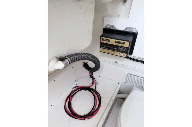 Slide: The Image of 2024 Sportsman Open 232 Center Console battery compartment with wiring and charger. - 25