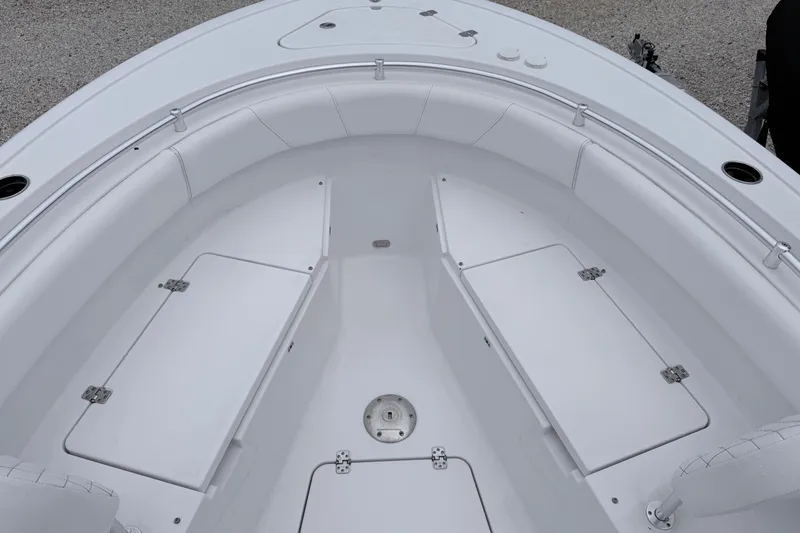 Slide: The Image of 2024 Sportsman Open 232 Center Console boat interior with white seating and storage compartments. - 19