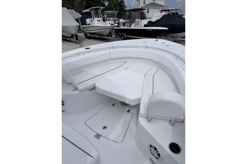 Slide: The Image of 2024 Sportsman Open 232 Center Console boat interior with white seating and storage compartments. - 22
