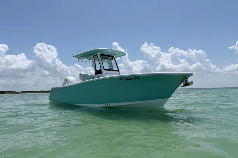 Slide: The Image of 2024 Sportsman Open 232 Center Console boat on calm turquoise water under a cloudy sky. - 3
