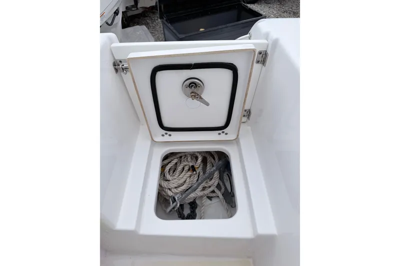 Slide: The Image of 2024 Sportsman Open 232 Center Console storage compartment with rope and anchor. - 8