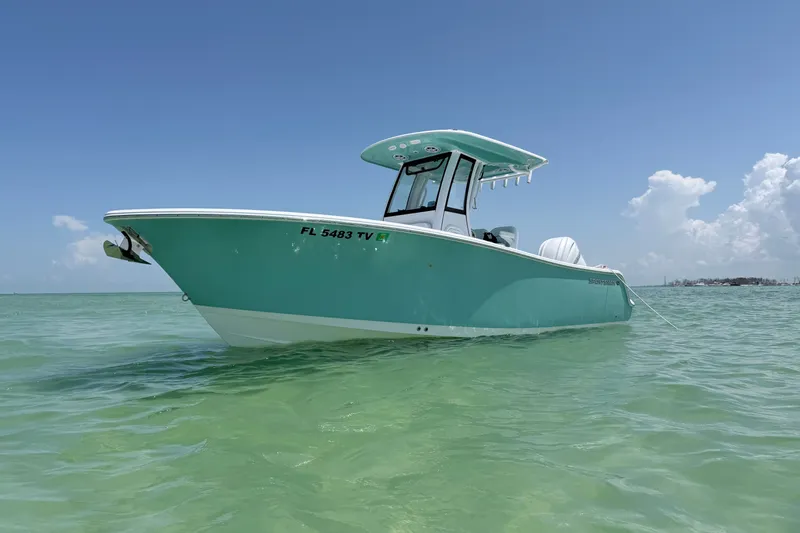 The Image of 2024 Sportsman Open 232 Center Console boat on clear turquoise water under blue sky. - 1
