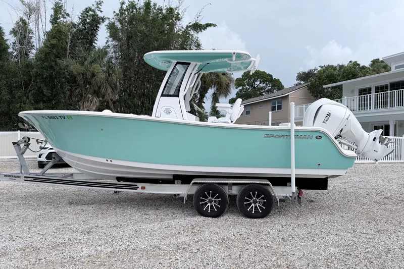 Slide: The Image of 2024 Sportsman Open 232 Center Console boat on trailer, mint green hull, parked outdoors. - 3