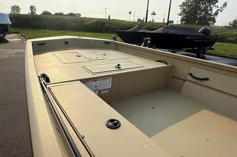 Slide: The Image of 2026 Crestliner 1860 Retriever Deluxe boat interior, showcasing spacious deck and storage compartments. - 8