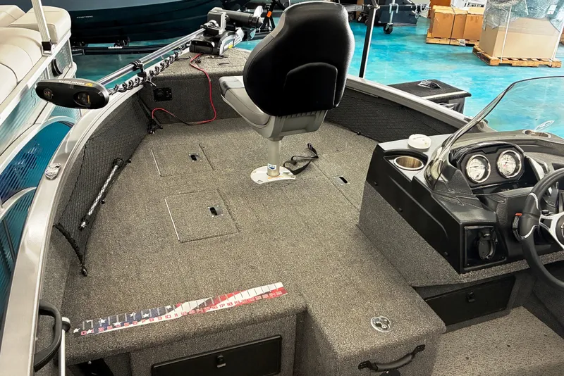 Slide: The Image of 2023 Crestliner 1650 Fish Hawk interior with seating, steering console, and fishing equipment. - 4