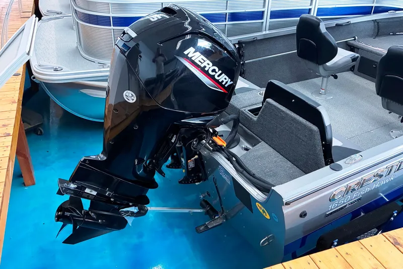 Slide: The Image of 2023 Crestliner 1650 Fish Hawk boat with Mercury outboard motor on blue water. - 1