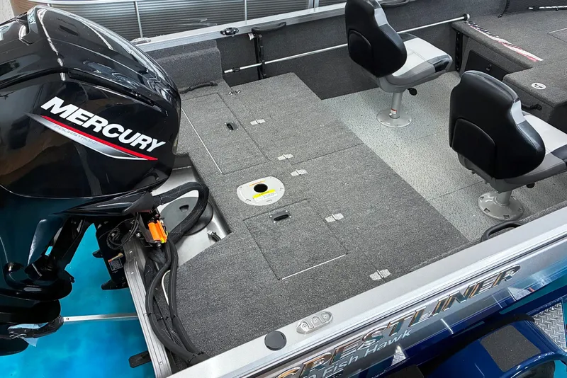 Slide: The Image of 2023 Crestliner 1650 Fish Hawk boat interior with Mercury engine, featuring seating and storage. - 7
