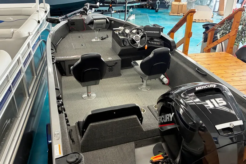 Slide: The Image of 2023 Crestliner 1650 Fish Hawk boat interior with Mercury engine, featuring seating and control console. - 2