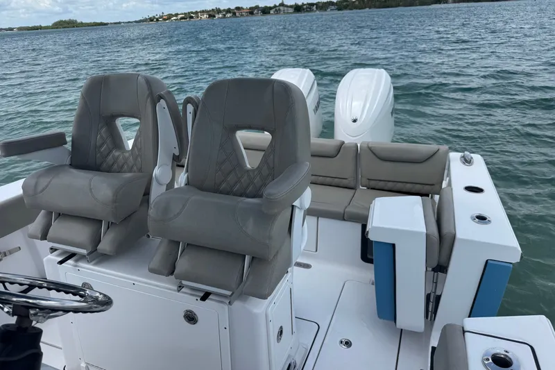 Slide: The Image of 2024 Sportsman Heritage 261 Center Console boat interior with dual seats and ocean backdrop. - 5