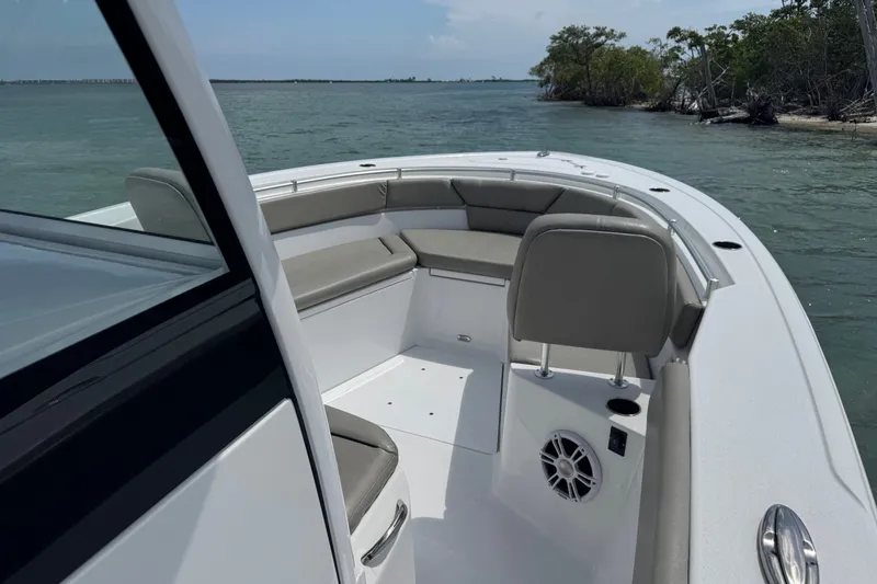 Slide: The Image of 2024 Sportsman Heritage 261 Center Console boat interior with seating, on calm waters. - 3
