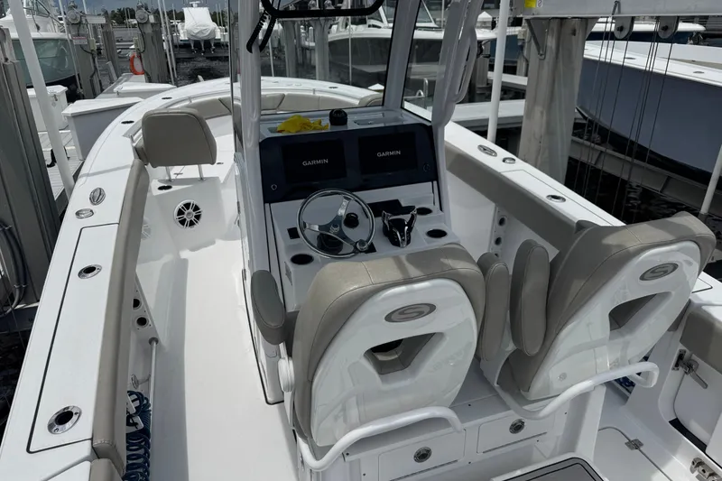 Slide: The Image of 2024 Sportsman Heritage 261 Center Console boat interior with dual Garmin displays and cushioned seating. - 16