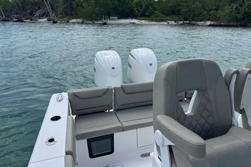 Slide: The Image of 2024 Sportsman Heritage 261 Center Console boat with dual engines on calm water. - 9