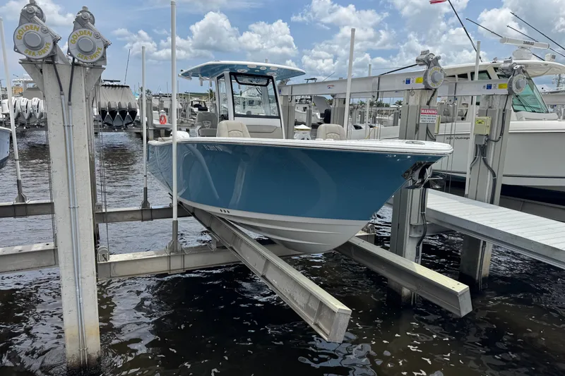 Slide: The Image of 2024 Sportsman Heritage 261 Center Console boat docked at marina, blue hull, clear sky. - 20