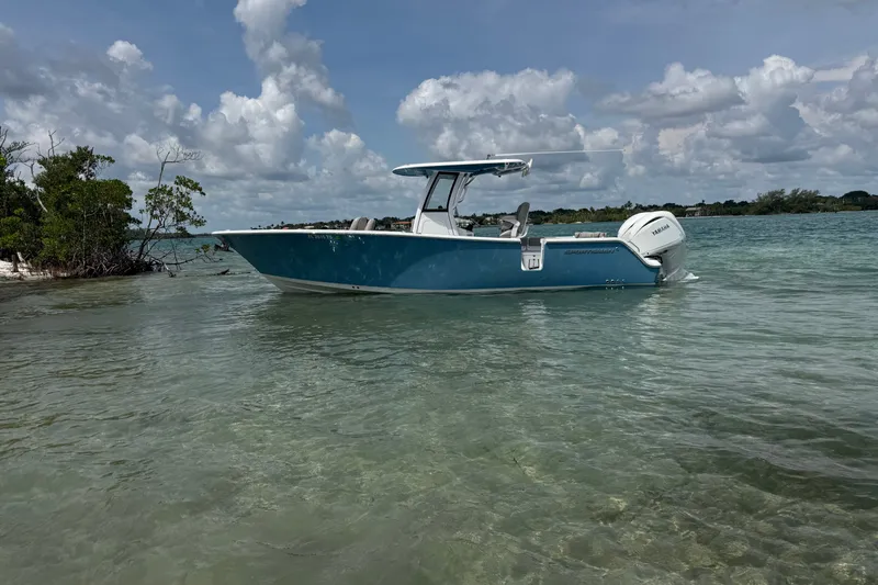 Slide: The Image of 2024 Sportsman Heritage 261 Center Console boat in clear coastal waters under a cloudy sky. - 1