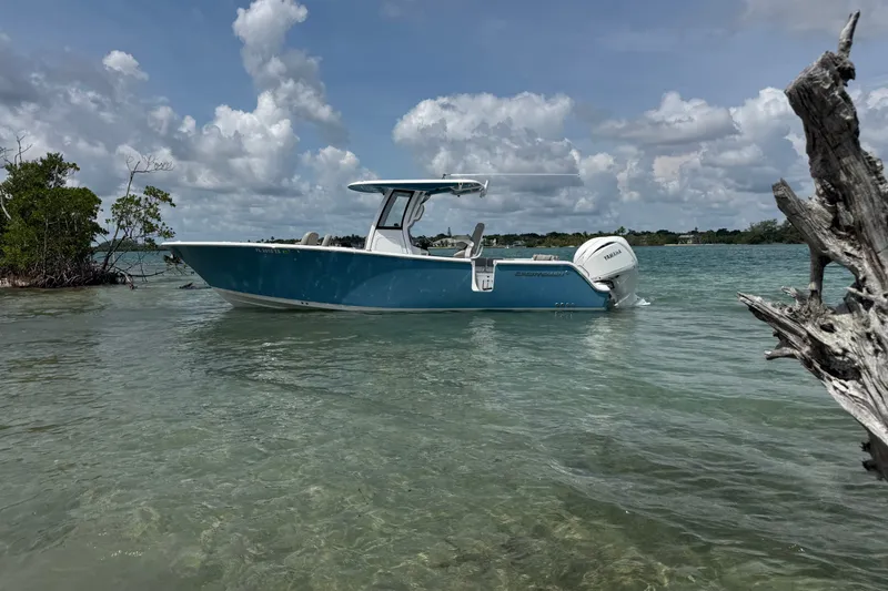 The Image of 2024 Sportsman Heritage 261 Center Console boat in clear coastal waters under cloudy skies. - 0