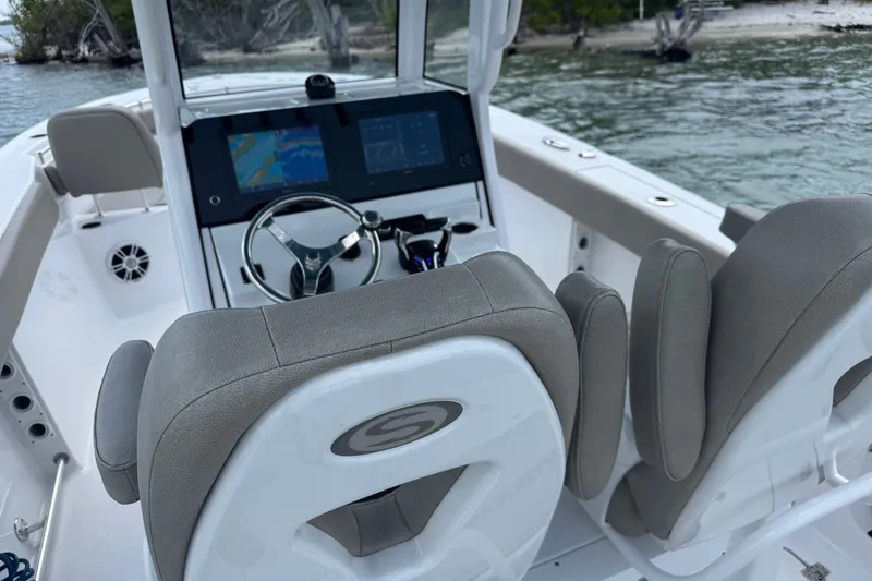Slide: The Image of 2024 Sportsman Heritage 261 Center Console boat interior with steering wheel and navigation screens. - 6