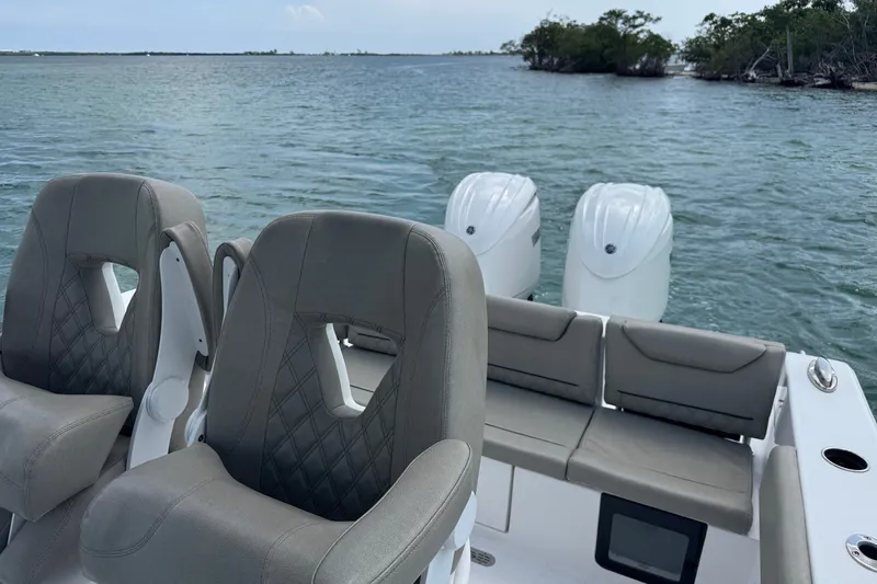 Slide: The Image of 2024 Sportsman Heritage 261 Center Console boat interior with dual engines on water. - 8