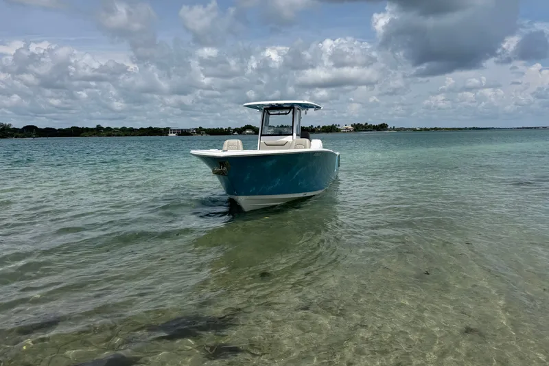 Slide: The Image of 2024 Sportsman Heritage 261 Center Console boat on clear, shallow water under cloudy sky. - 2