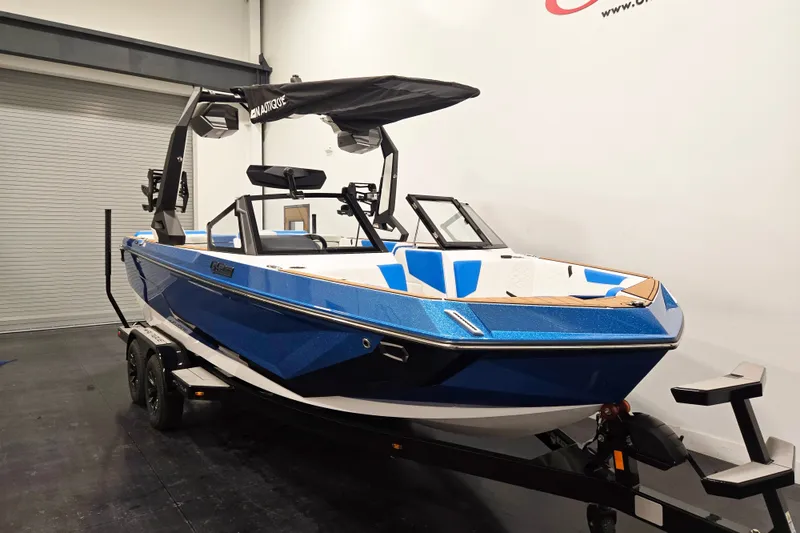Slide: The Image of 2027 Nautique Super Air Nautique GS20 boat in showroom, blue exterior, on trailer. - 2