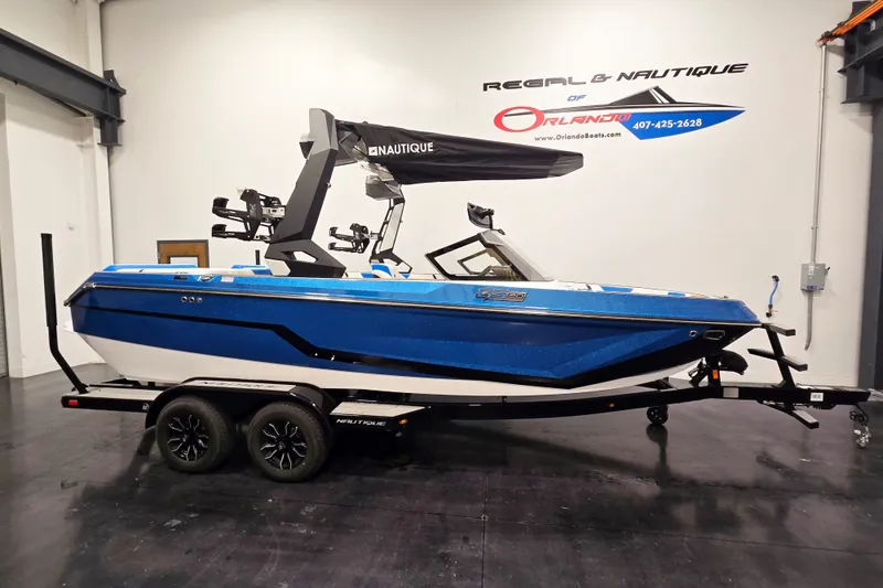 The Image of 2027 Nautique Super Air Nautique GS20 boat in showroom, blue exterior, on trailer. - 1