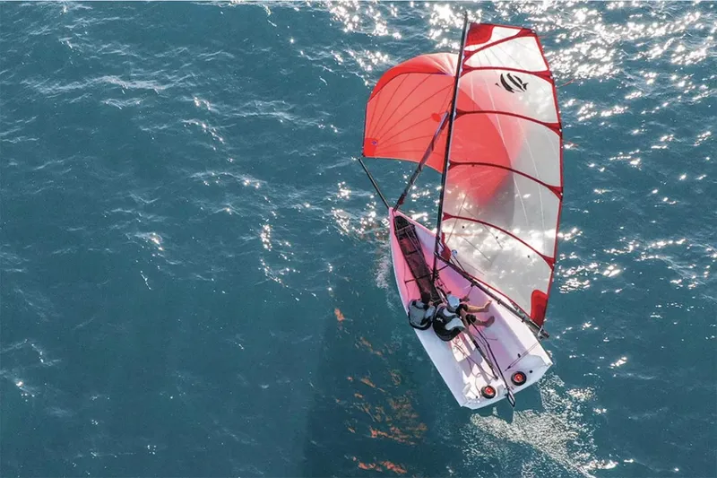 Slide: The Image of Manufacturer Provided Image: 2026 Beneteau First 14 SE sailing on open water with vibrant red sails. - 2