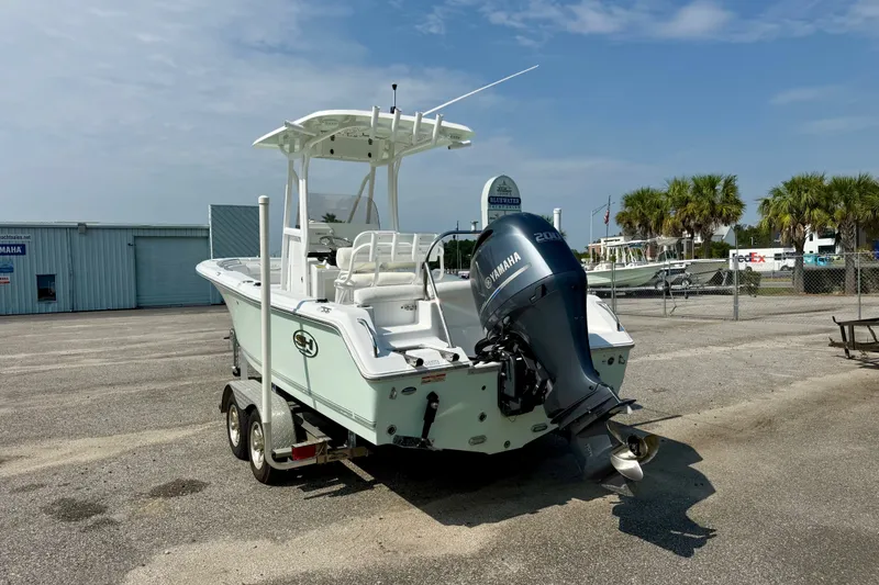 Slide: The Image of 2016 Sea Hunt Ultra 211 boat with Yamaha engine on trailer in sunny marina. - 2