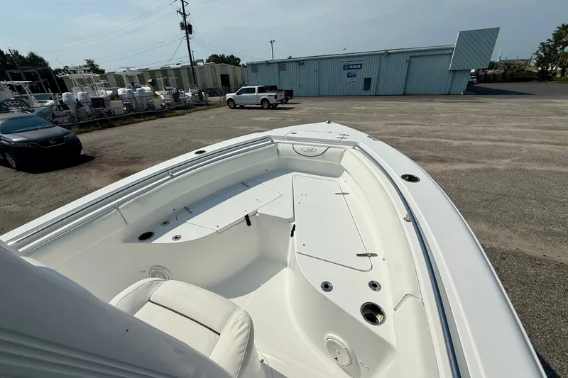 Slide: The Image of 2016 Sea Hunt Ultra 211 boat interior at a marina, showcasing seating and storage. - 10