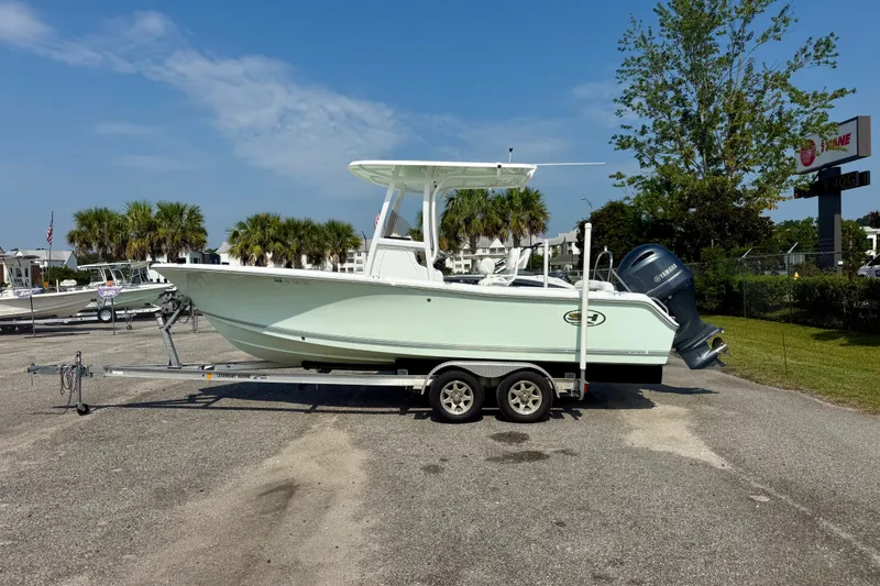 Slide: The Image of 2016 Sea Hunt Ultra 211 boat on trailer, parked outdoors under clear sky. - 1