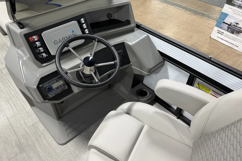 Slide: The Image of Interior of 2025 Qwest 8518 LANAI LT boat with steering wheel and Garmin display. - 2