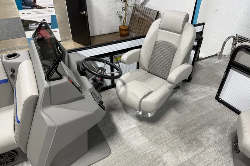 Slide: The Image of 2025 Qwest 8518 LANAI LT boat interior with modern helm and comfortable captain's chair. - 5