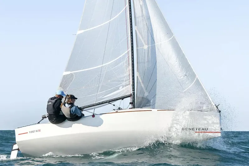 The Image of Manufacturer Provided Image: 2026 Beneteau First 18 SE sailboat navigating ocean waves with crew onboard. - 2