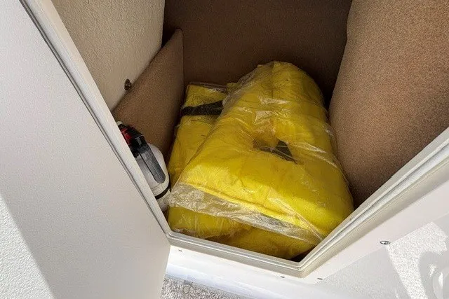 Slide: The Image of Yellow life jackets stored in a compartment of a 2012 Chaparral 19 H2O Ski & Fish boat. - 22
