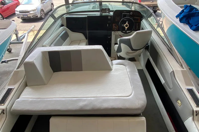 Slide: The Image of Interior view of a 1990 MasterCraft Maristar 240 with white upholstery and a helm station. - 9