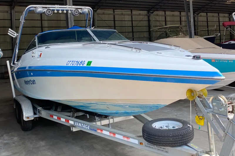 Slide: The Image of A 1990 MasterCraft Maristar 240 on a trailer in a covered area. - 1