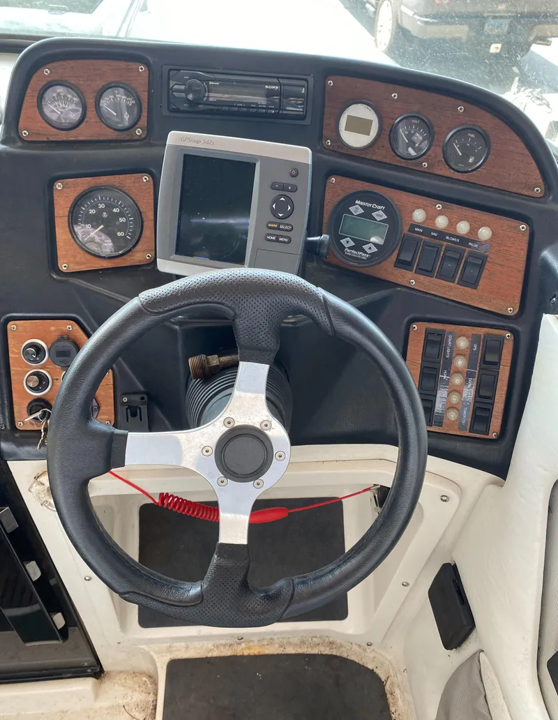 Slide: The Image of The image shows the dashboard of a 1990 MasterCraft Maristar 240 with various instruments and a steering wheel. - 12