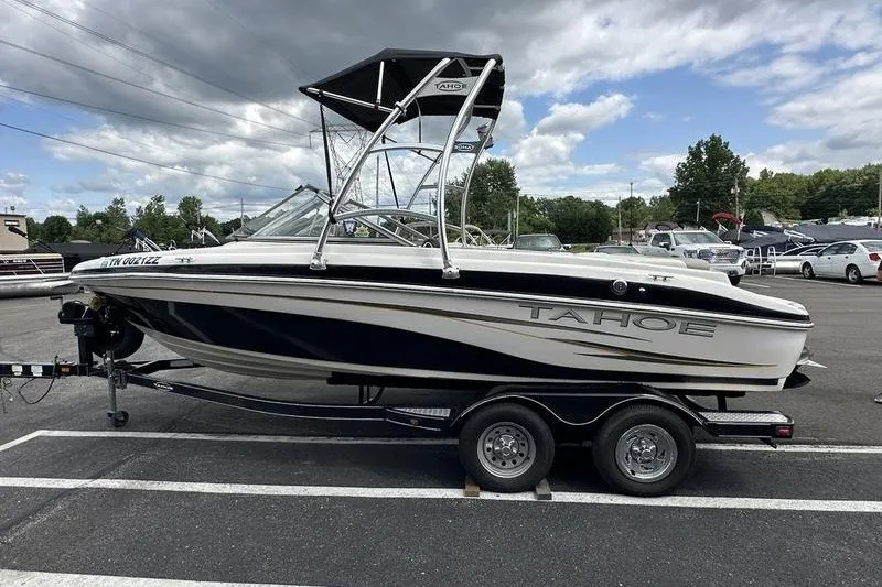Slide: The Image of 2008 Tahoe Q6 Sport boat on trailer in parking lot under cloudy sky. - 4
