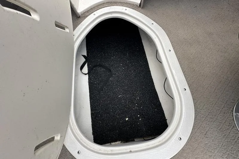 Slide: The Image of Open storage compartment in 2008 Tahoe Q6 Sport boat, featuring black mat inside. - 15
