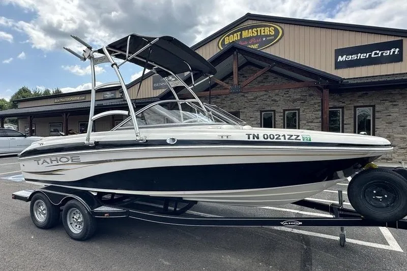 Slide: The Image of 2008 Tahoe Q6 Sport boat on trailer outside dealership under cloudy sky. - 2