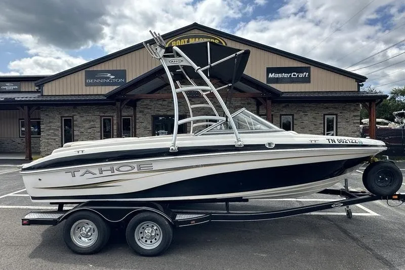 The Image of 2008 Tahoe Q6 Sport boat on trailer, parked outside dealership under cloudy sky. - 1