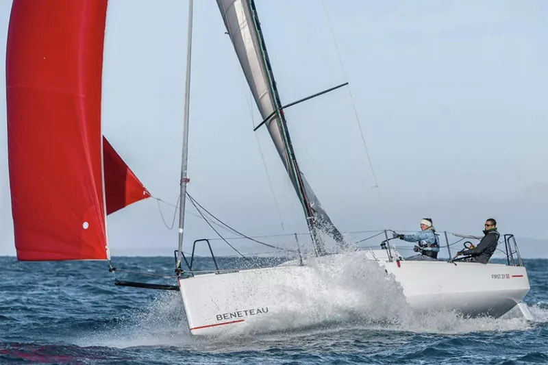 Slide: The Image of Manufacturer Provided Image: 2026 Beneteau First 27 SE sailboat navigating with red spinnaker on open water. - 2