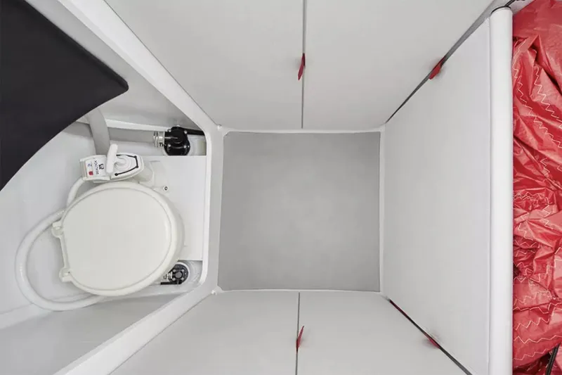 Slide: The Image of Manufacturer Provided Image: Interior of 2026 Beneteau First 27 SE sailboat, featuring compact marine toilet. - 4