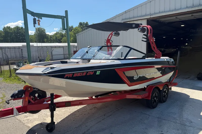 Slide: The Image of 2020 Nautique Super Air Nautique GS20 boat on a red trailer outside a warehouse. - 6