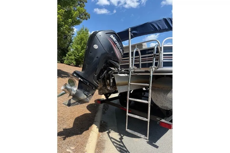 Slide: The Image of 2019 Ranger Reata 200C boat with Mercury outboard motor and ladder, parked outdoors. - 11